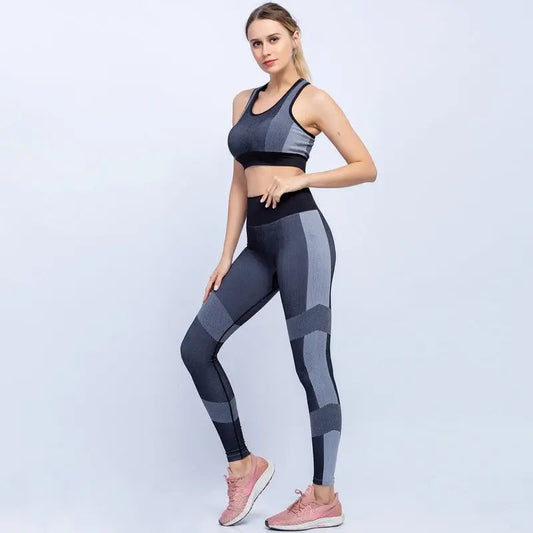 Woman wearing gray fitness sport seamless yoga set with geometric patterns and pink sneakers standing against a white background
